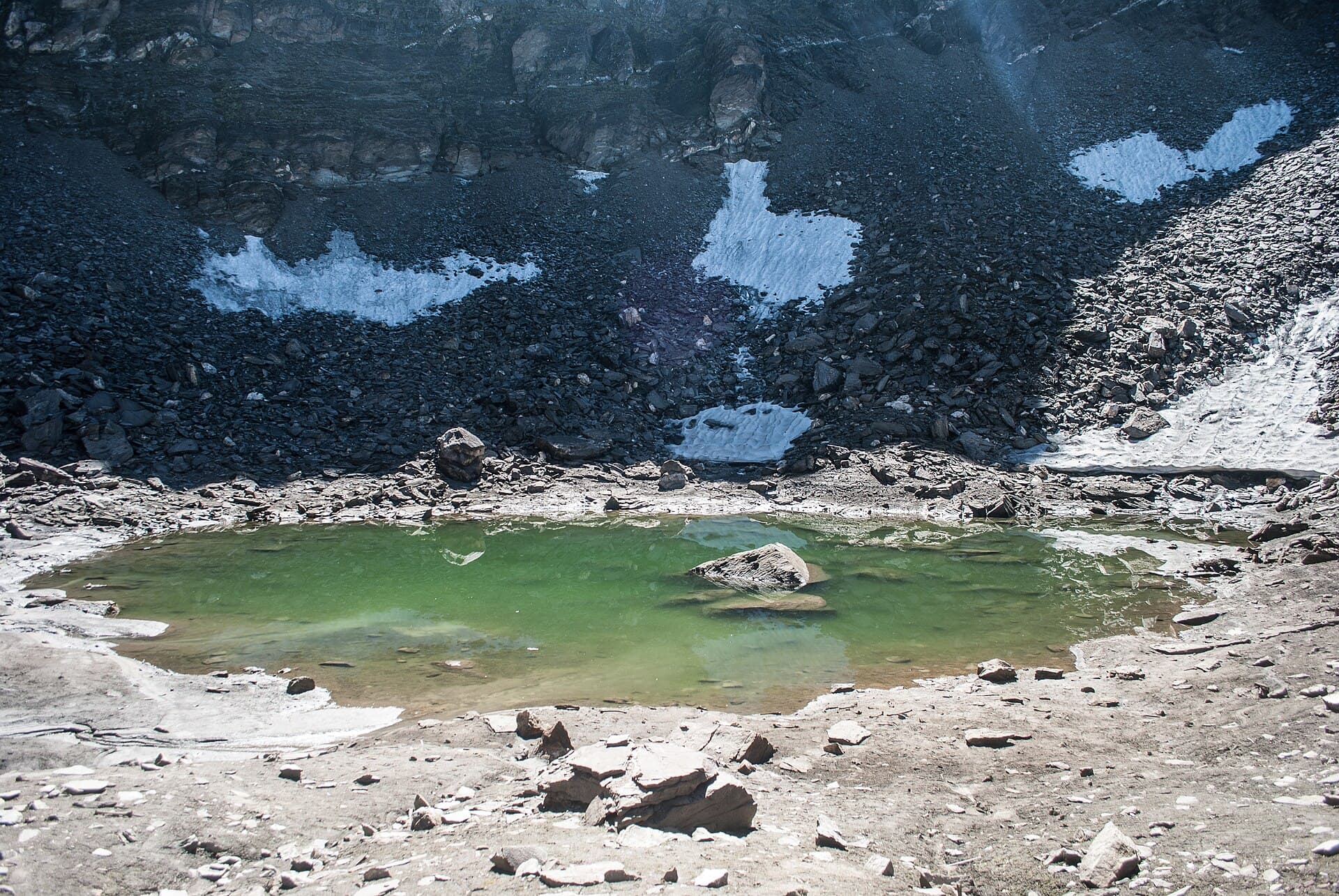 Roopkund lake, a small glacial lake below snow-covered ridgelines in Uttarakhand